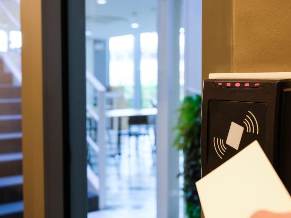 Men hand reaching to use RFID key card to access to office building area and workspace. In building security only for authorized person